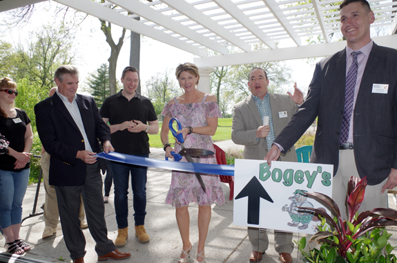 Cyndy Montana opens Bogey's, a restaurant at the Beaver Island Golf Course, as Jim Sharpe, left, and C.J. Girard of the Grand Island Chamber of Commerce hold the ceremonial ribbon. (Photo by Larry Austin)