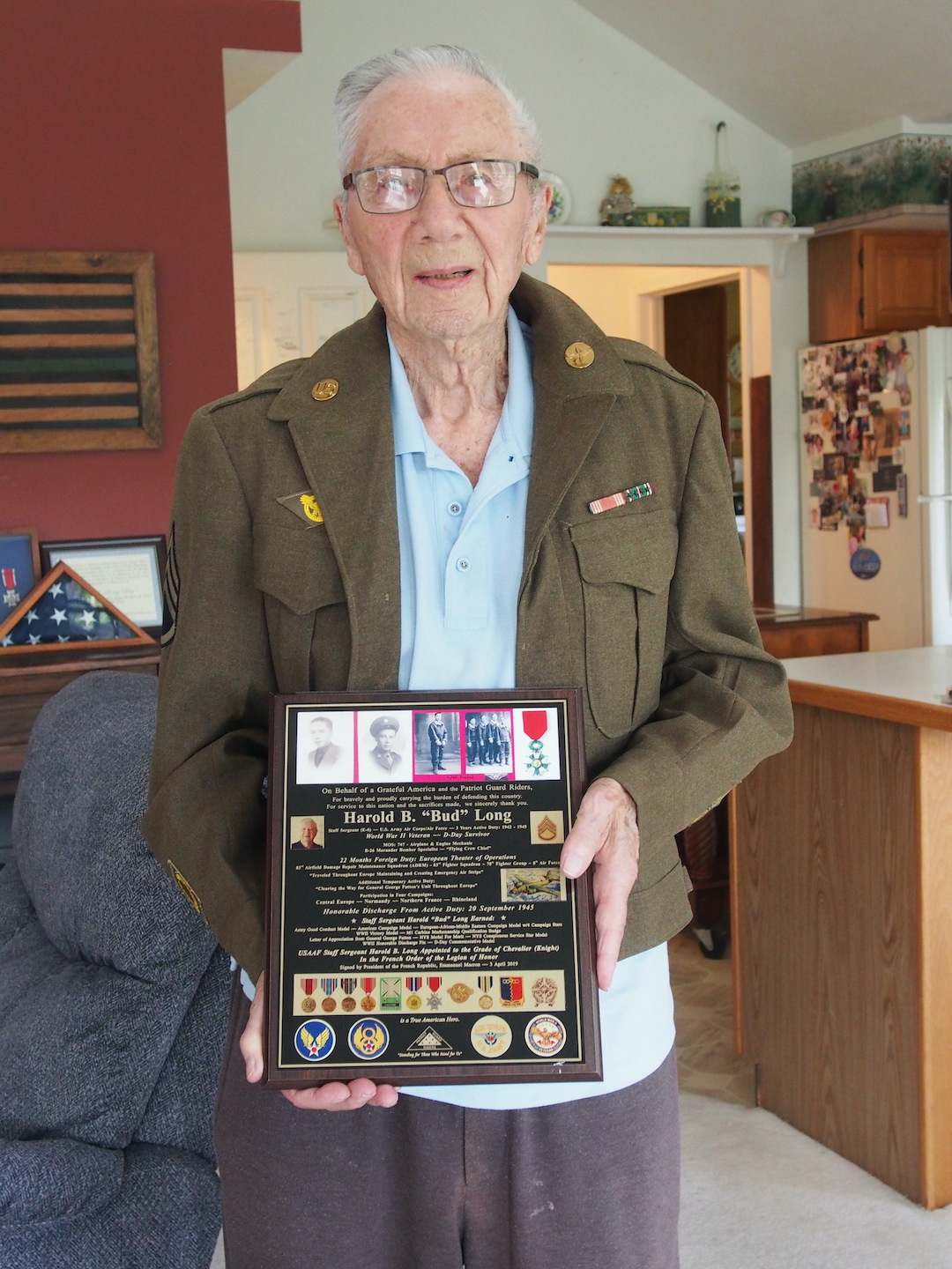 Bud Long shows one of the plaques describing his military service during World War II.