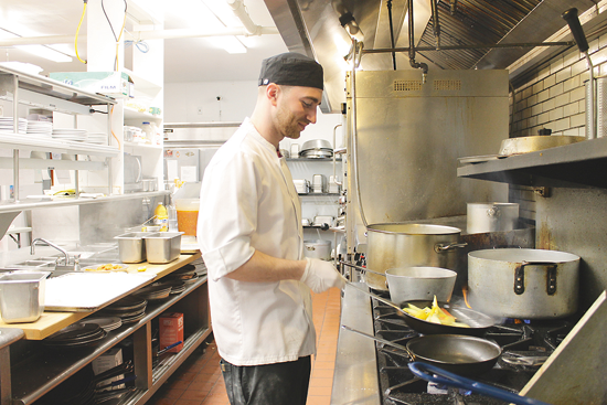 Head chef Peyton Fadel sautés some vegetables in the kitchen of the Buffalo Launch Club.