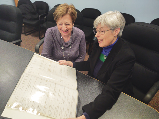 Elsie Martino, left, and Mary Cooke review a page in the Civil War book.
