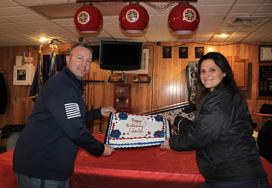 Bill and Sheara Snyder hold up the cake in honor of the 100th birthday of Pfc. Charles N. DeGlopper at the VFW Post 9249, named in his honor, on Nov. 30. (Photo by Karen Carr Keefe)