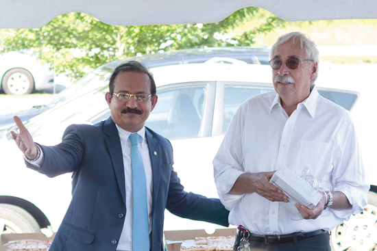 Sanjay Chadha, left, senior vice president for service line operations at Niagara Falls Memorial Medical Center, praises Dr. Willard Ruth Wednesday during the doctor's retirement get-together at Grand Island Family Practice. (Photo by Larry Austin)