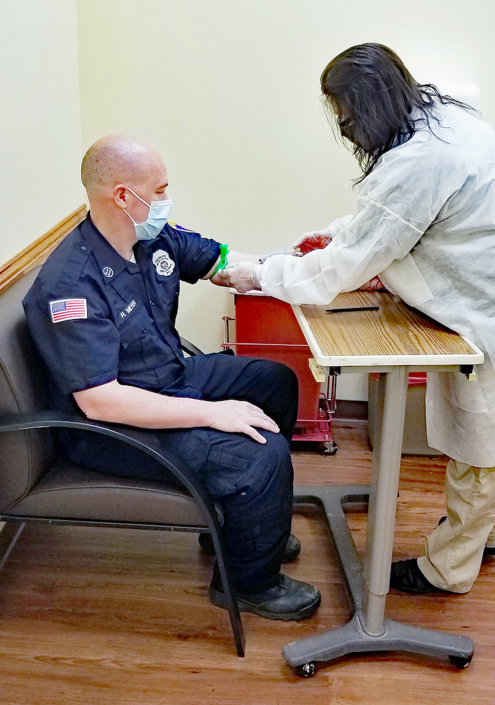 Laboratory Assistant Jane Markarian, right, draws a blood sample for antibody testing from Grand Island Fire Co. EMS Director Robert Meyer at Niagara Falls Memorial Medical Center's Porter Road Patient Service Center in the Town of Niagara.