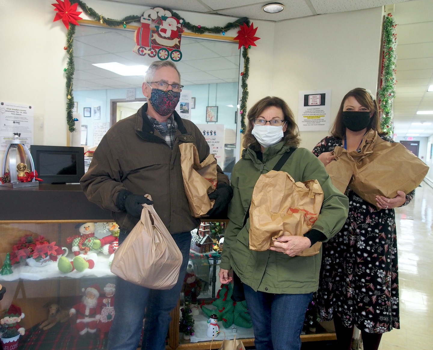 Dave and Sally Goris are shown with donations from the Grand Island Golden Age Center, along with Recreation Supervisor Jen Menter. (Photo by Alice E. Gerard)