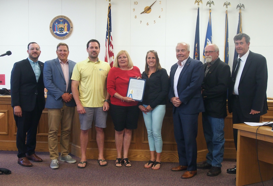 Claudia Schmitz, center, holds the proclamation issued by the Grand Island Town Board, honoring her late husband, Rick Schmitz II, as the leader of the water station for the annual Dick Bessel run. With her are her daughter, Jill Metz, and her son, Richard Schmitz III.