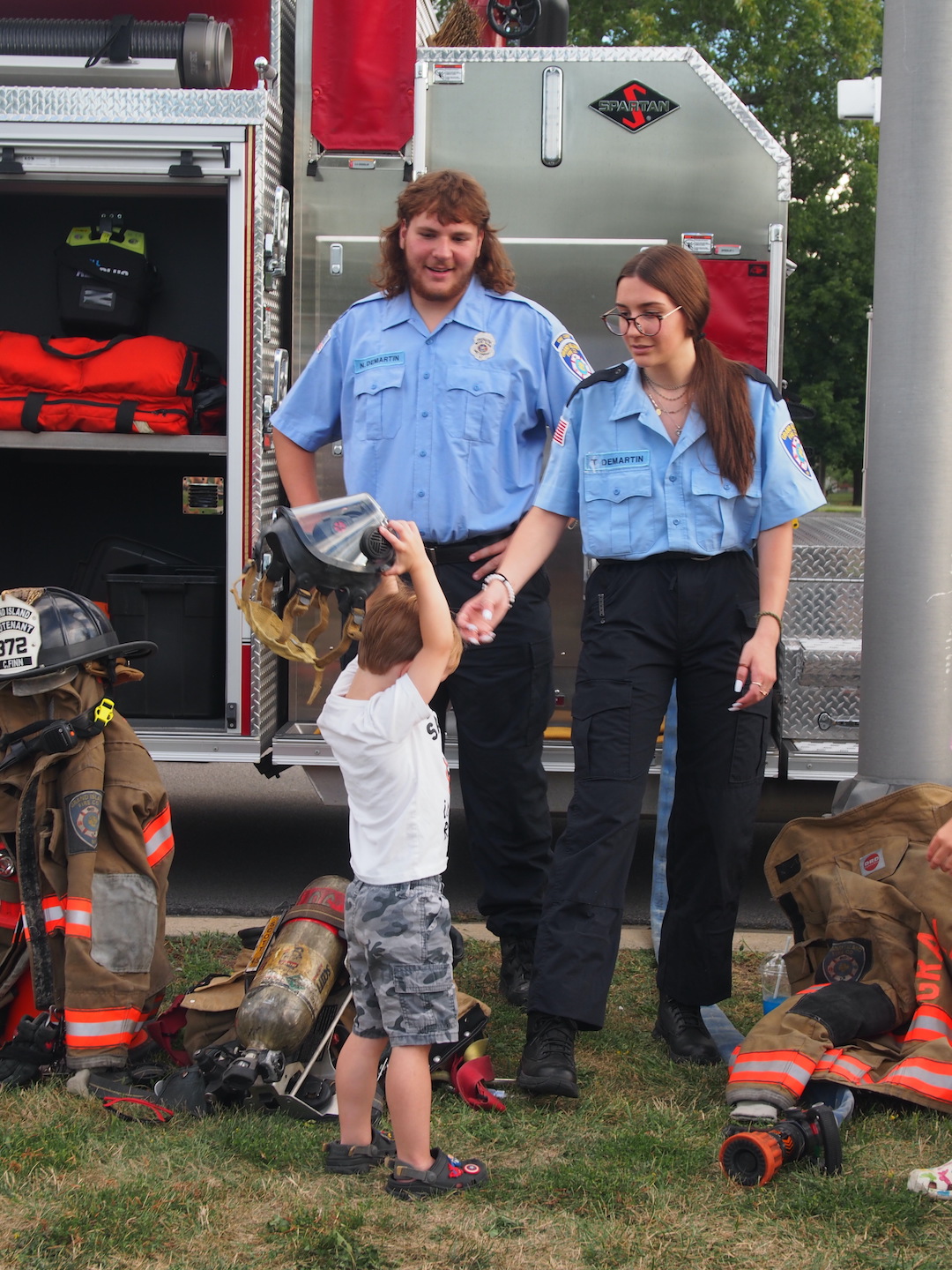 Volunteers with the Grand Island Fire Company demonstrate the truck for a young visitor.