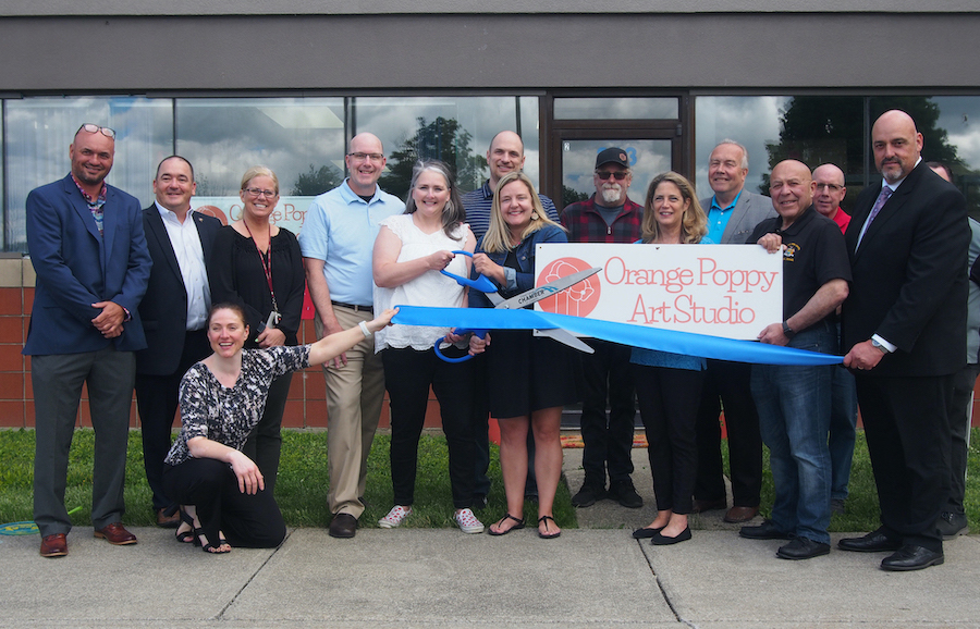 Members of the Grand Island Chamber of Commerce, New York State Assemblyman Angelo Morinello, town officials (including Supervisor John Whitney, Highway Superintendent Richard Crawford, Councilman Pete Marston, and Clerk Pattie Frentzel), and friends of the Orange Poppy Art Studio celebrate a ribbon cutting with owners Crystal Still and Bonnie Nevans.