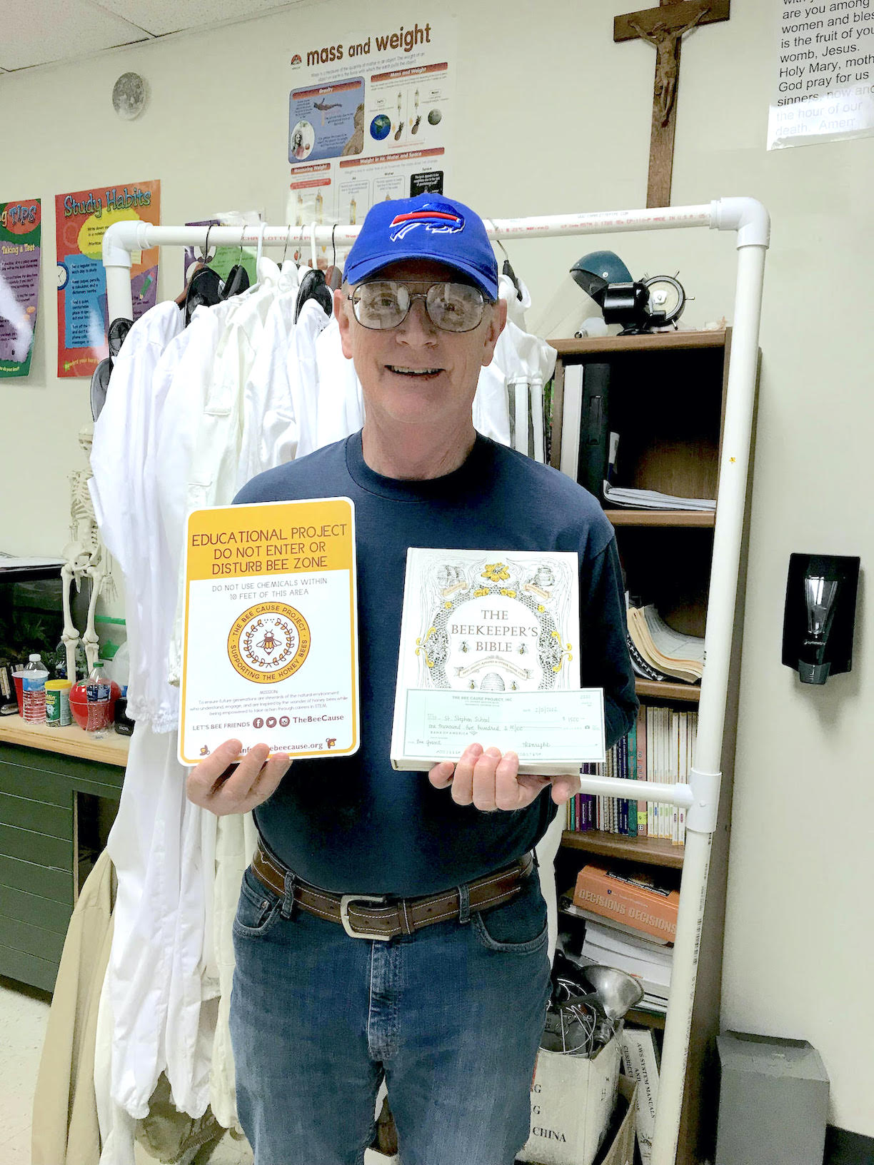 Phil Kenline stands in his science room with the beekeeper suits that his students will wear when working with the beehives the students will maintain this spring. (Submitted photo)