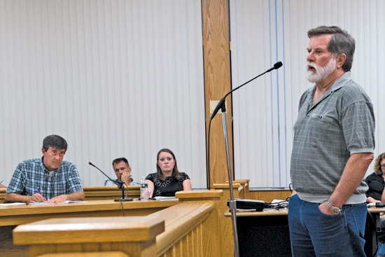 Resident Bob Henschel speaks during a public information meeting at Town Hall Monday regarding the proposed Southpointe development as council members Mike Madigan and Jennifer Baney listen. (Photo by Larry Austin)