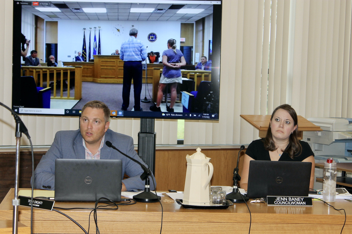 Council members Thomas Digati, left, and Jenn Baney listen as Long Range Planning Committee Chair Jim Sharpe and committee citizen-at-large Martha Ludwig (seen in the monitor above the council members) present a case to the Town Board for making the committee an advisory board, during the July 19 workshop meeting of the Town Board. Sharpe said the committee has been studying how better to achieve consistency and continuity in town planning.
