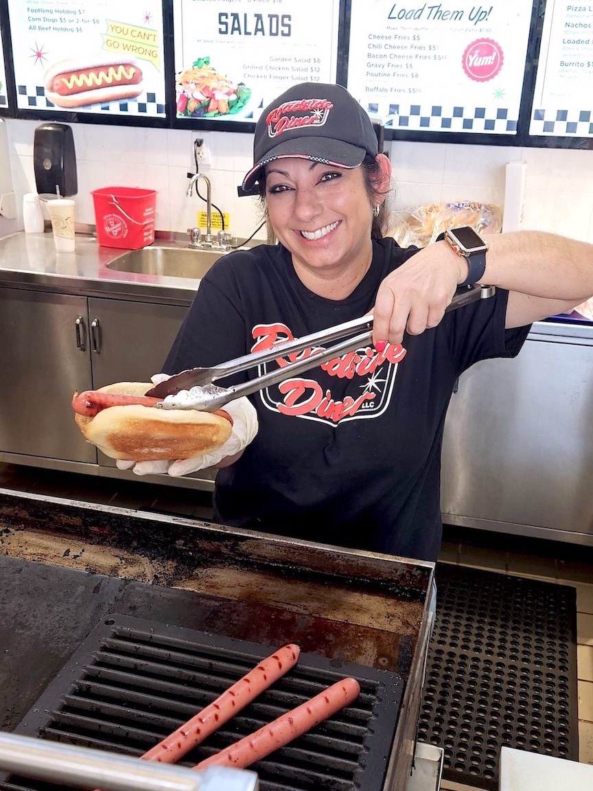 Roadside Diner owner Jennifer Pettitt serves up a hot dog on opening day at the Fashion Outlets of Niagara Falls USA. (Submitted)