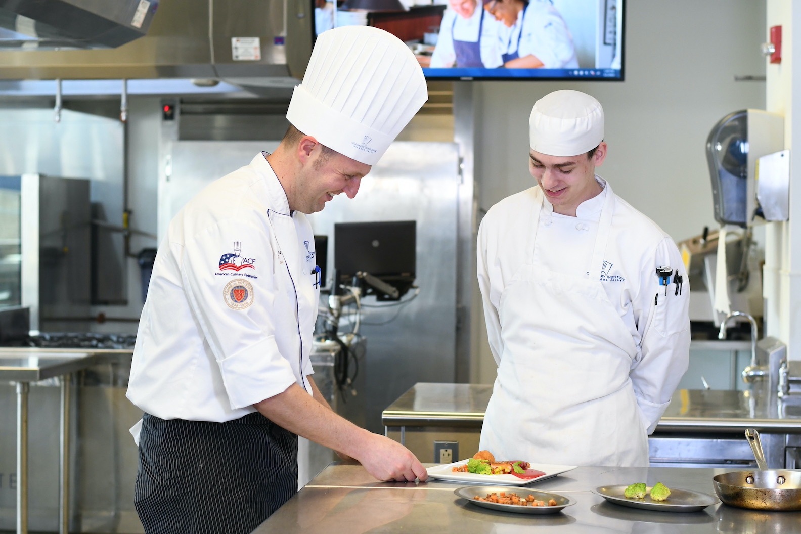 Award-winning chef instructor Scott Steiner trains former Niagara Falls Culinary Institute student Antonio LaBarbera in a culinary lab. (NCCC photo)