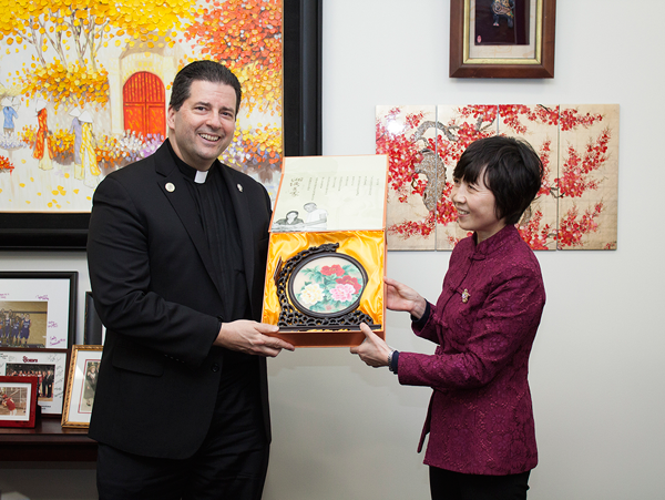 The Rev. James J. Maher, C.M., president of Niagara University, is presented with a gift by Tong Xiaojiao, president of China's Hunan First Normal University, during a meeting at NU on May 3.