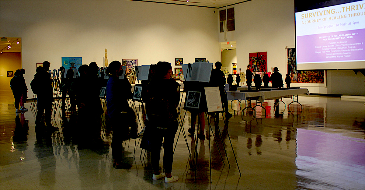Attendees view artwork created by survivors of domestic violence at the fifth `Surviving...Thriving: A Journey of Healing Through Art` exhibit, held in observance of Domestic Violence Awareness Month. (NU photo)