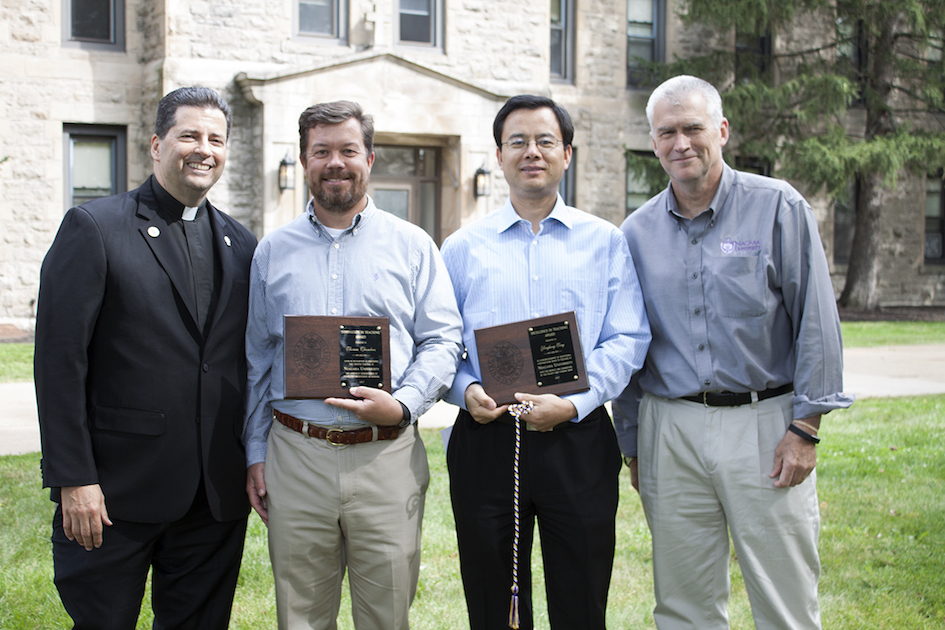 Drs. Thomas Chambers and Yonghong Tong are congratulated for winning the Innovation in Teaching Award and the Excellence in Teaching Award, respectively, by the Rev. James J. Maher, C.M., president of Niagara University, and Dr. Timothy Ireland, NU's provost.