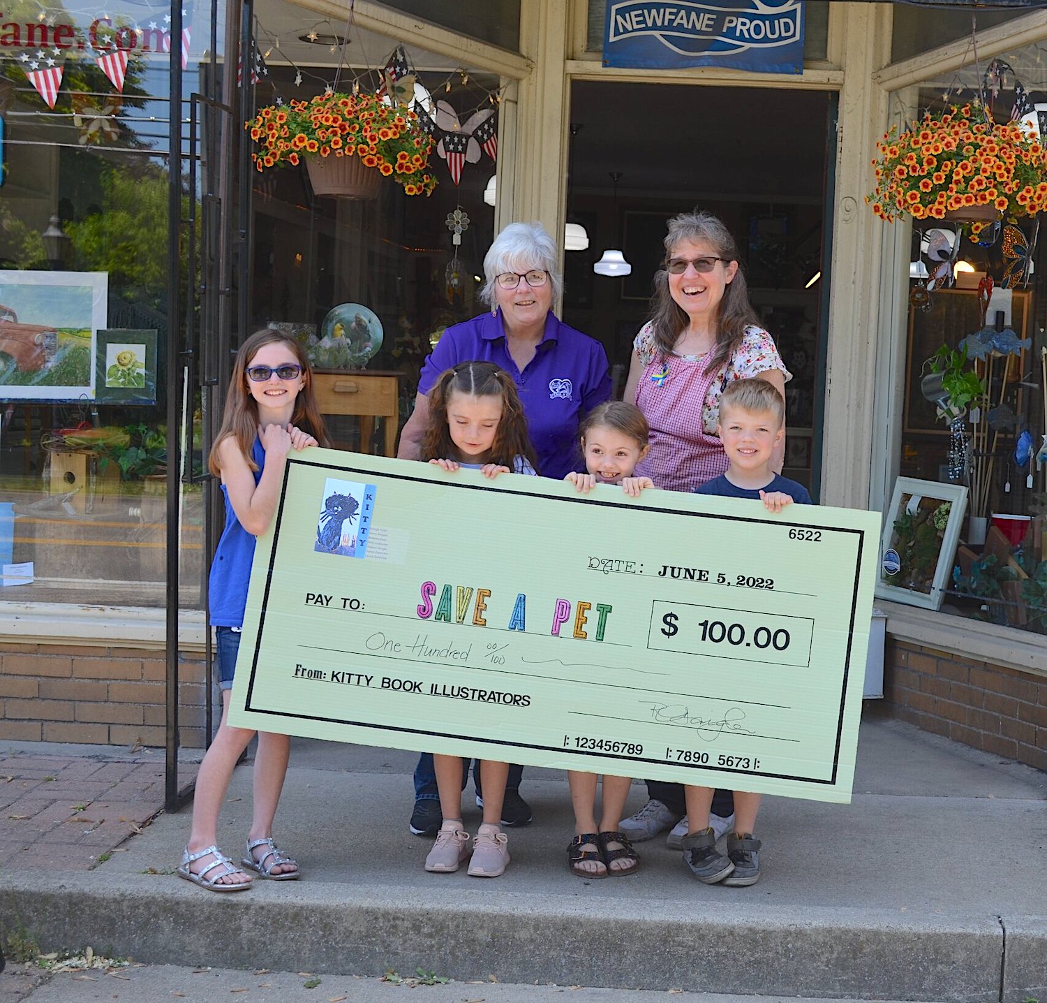 Ryleigh, Addison, Abby, Henry and Miss Rhonda from Lazy Creek Art present Save-A-Pet Niagara President Ednamarie Wolff with a $100 check from initial sales of their picture book, `Kitty.` (Submitted photo)