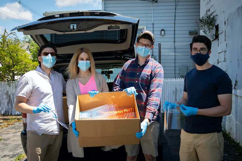 Jacobs School medical students (from left) Jordan Levine, Brittany Russell, Mitch Eyerman and Joshua Broden, with another load of face shields they produced and donated to protect frontline workers in Buffalo. (Photo by Meredith Forrest Kulwicki, University at Buffalo)