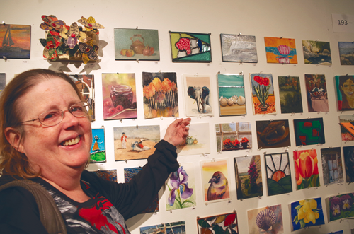 Deb Meier points to a water color she painted and then donated to the Carnegie Center's `Art Off the Wall` fundraiser.