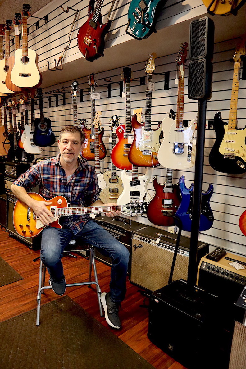 Lewiston Music owner Tony Petrocelli strums a Gibson Les Paul inside his new store on Military Road.