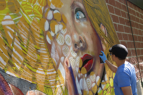 Chuck Tingley works on a permanent mural at Artpark in Lewiston. 
