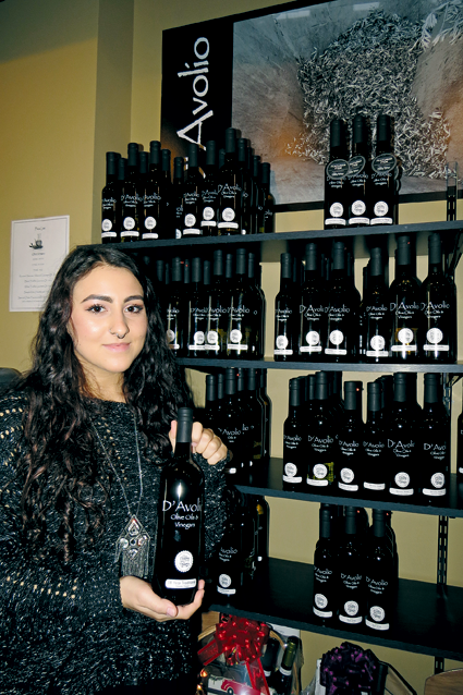 Olivia Nicoletti poses with some products inside D'Avolio Olive Oils and Vinegars.
