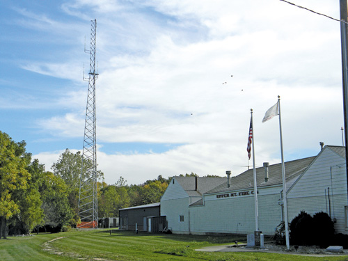 The 219-foot tower behind Upper Mountain Fire Co. is a source of controversy.