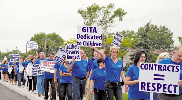 Members of the Grand Island Teachers' Association picket on the Ransom Road sidewalk in front of Grand Island High School Monday before the Grand Island Board of Education meeting. The union representing district teachers has been without a new contract for a year.
