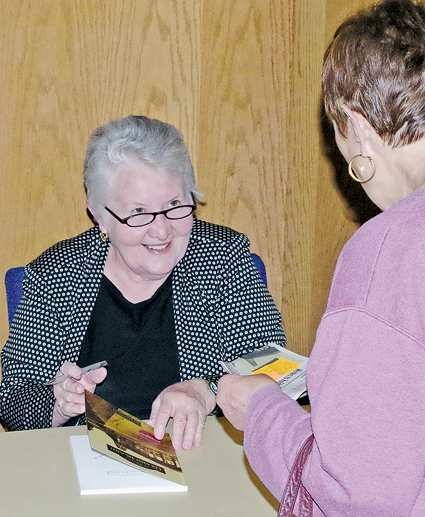 June Crawford signs a copy of her book 