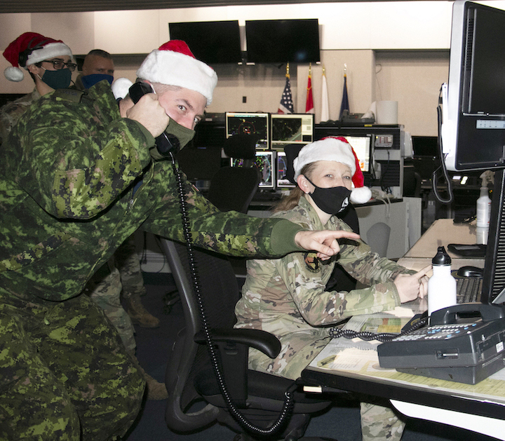 Royal Canadian Air Force Capt. Kevin Vincent, standing, and Airman 1st Class Megan Mills of the New York Air National Guard's 224th Air Defense Squadron train for Santa tracking operations. (Submitted photo)