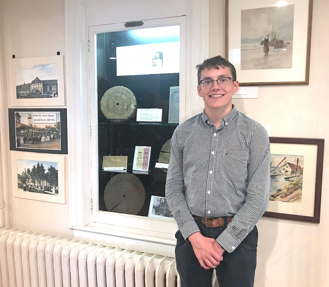 Niagara History Center curatorial intern Josh Poole stands in the museum's changing exhibit room, which now displays artifacts and other materials related to the history of Olcott Beach. He researched, wrote and assembled the exhibit while working at the History Center this summer. (Submitted photo)