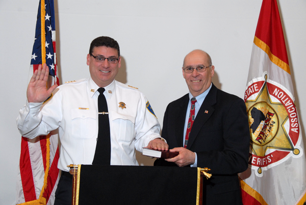 Niagara County Sheriff Voutour (left) is sworn in as a president of the state Sheriffs Association by Thomas Beilein (right), chairman of the state Commission of Correction, at the installation of officers during the Association's 81st annual Winter Training Conference at the Desmond in Albany.