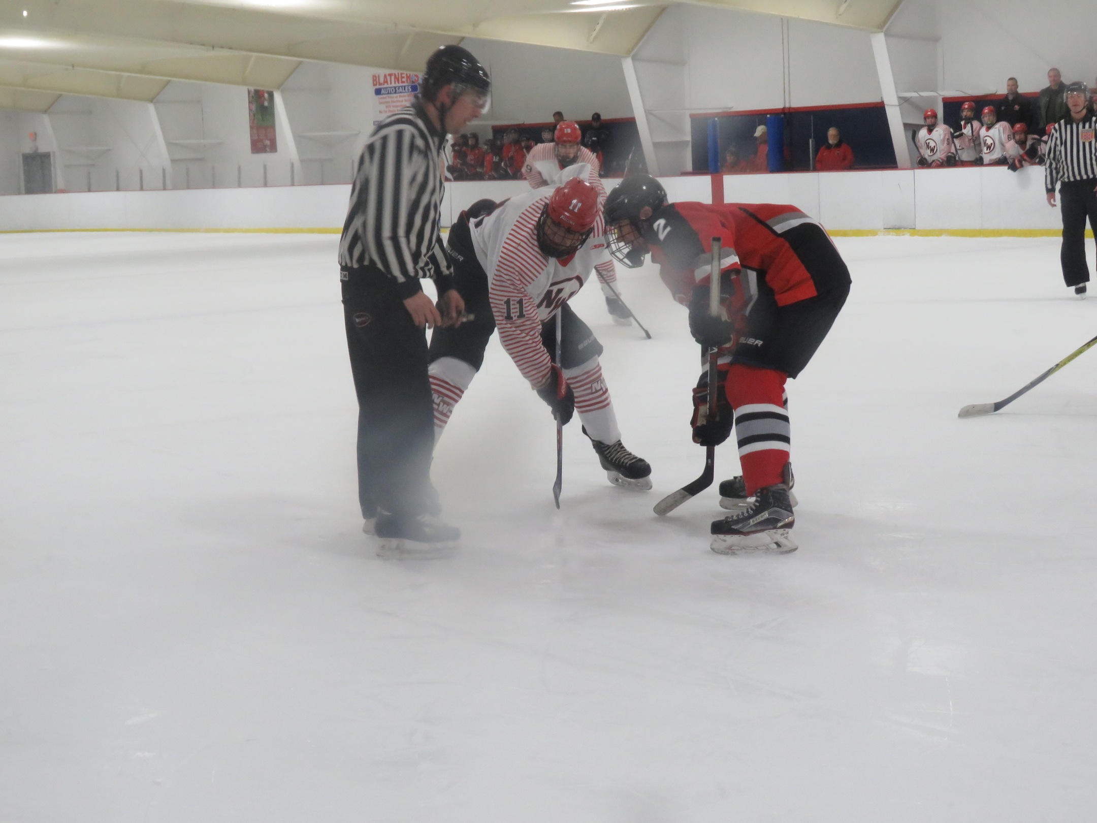 Chace Woods duels for a faceoff with Clarence's Noah Corry at Tuesday's Division 1 contest at the Hockey Outlet. (Photo by David Yarger)