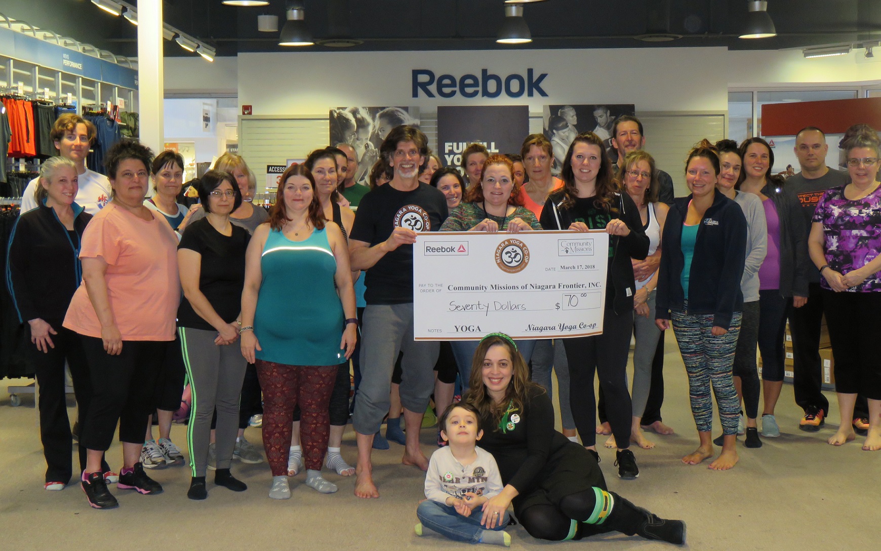 Members from Niagara Yoga Co-op's Saturday session pose for a photo following the event. Holding the check, from left, Brian Ball, Stacey Menard and Nicole Quarantillo. (Photo by David Yarger)