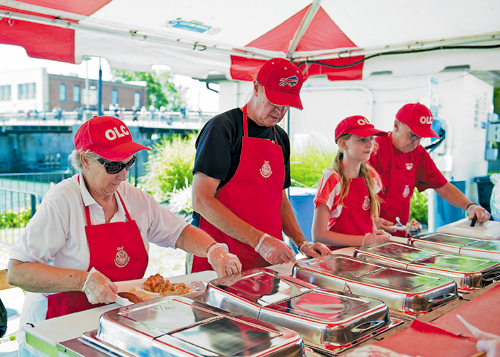 Our Lady of Czestochowa Parish in North Tonawanda runs one of the most popular concessions tents at the Canal Fest of the Tonawandas. From left, Gloria Nowak, Jim Kowalski, Kaila Marazita and John Nowak put together a Polish platter on the opening day of the festival. (Photo by Karen Gioia.)