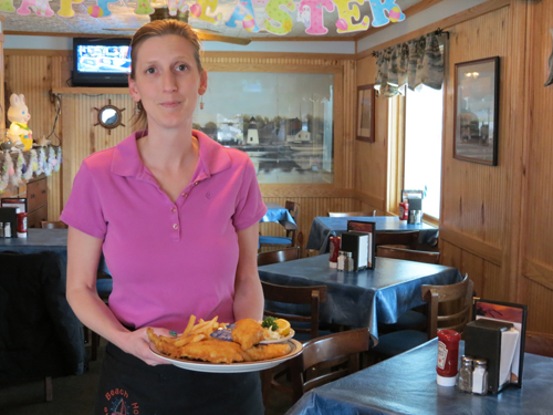 The Beach House's Dawn Heitman holds up a fish fry dinner.