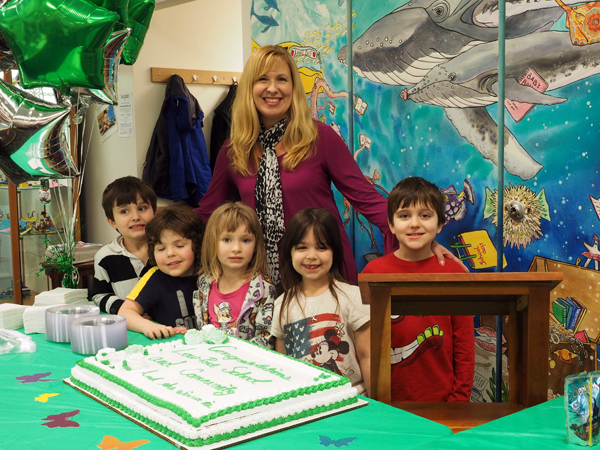 PEC Principal Tamara Larson, with students and the Tops cake at the Lewiston Public Library `Reveal Party.` 